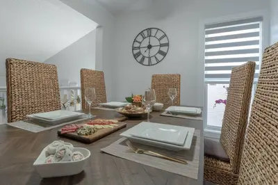 a dining room with a table with chairs and a clock at Chic Romantic3bed patio WIFI quiet retreat parking in Calgary
