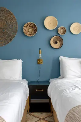 two beds in a room with a blue wall at Kettle Valley Beach Resort in Penticton