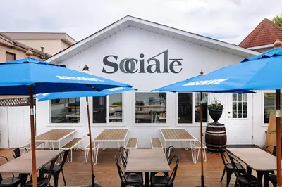 a patio with tables and umbrellas in front of a saale building at Kettle Valley Beach Resort in Penticton