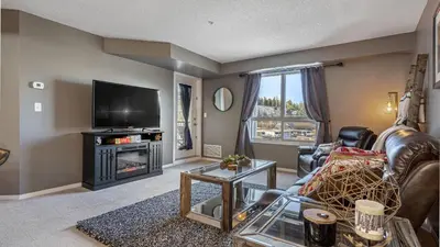 a living room with a couch and a tv at Cozy Mountain I Hot Tub & Pool I Close 2 Lake I TV in Invermere