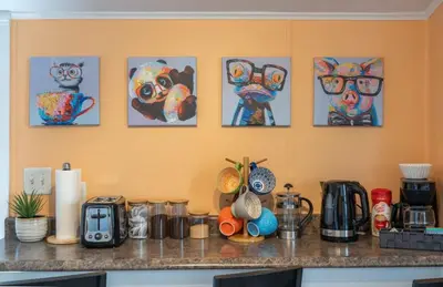 a counter with some paintings on a wall at Dino Cave l Walk to Downtown l Fire Pit & BBQ I TV in Drumheller