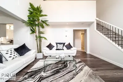 a living room with a white couch and a glass table at LUXURIOUS 6 Bed Home I Fireplace I near Sports Park I with Double Garage & Fast WiFi! in Edmonton