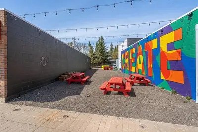 a group of red picnic tables next to a wall at The Hidden Loft I 5-min Walk 2 Beach I DT I 55 TV in Sylvan Lake