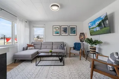 a living room with a couch and a table at The Hidden Loft I 5-min Walk 2 Beach I DT I 55 TV in Sylvan Lake