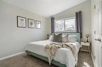a bedroom with a bed and a window at Timber Valley I HotTub I PingPong I Sleep 14 I BBQ in Drumheller