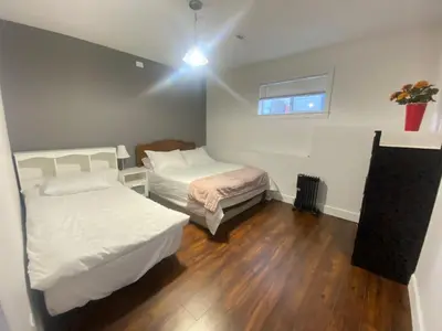 a small room with two beds and a window at lovely home in Calgary