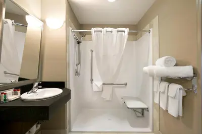 a white bathroom with a shower and a sink at Ramada by Wyndham Conklin in Conklin