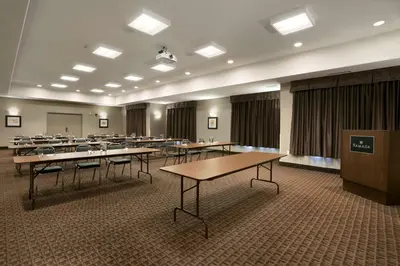 a conference room with tables and chairs and a podium at Ramada by Wyndham Conklin in Conklin