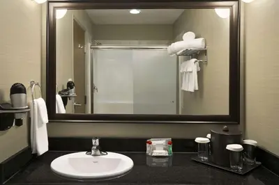 a bathroom with a sink and a large mirror at Ramada by Wyndham Conklin in Conklin