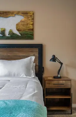 a bedroom with a bed and a lamp on a nightstand at Prairie Oasis I Sleeps 16 l BBQ & Patio l Smart TV in Sylvan Lake