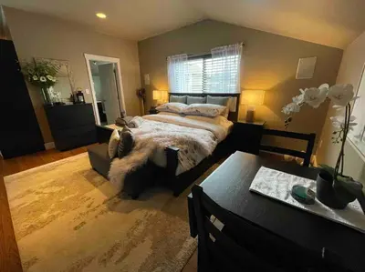 a bedroom with a large bed and a table at Cozy loft in Upper Gibsons in Gibsons