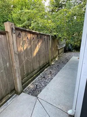 a wooden fence with a sidewalk in front of it at Cozy loft in Upper Gibsons in Gibsons