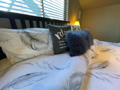a blue teddy bear sitting on top of a bed at Cozy loft in Upper Gibsons in Gibsons
