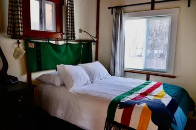 a bedroom with a bed and a window at Banff Beaver Cabins in Banff