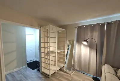 a room with a book shelf and a lamp at UofC-SAIT-Banff Trail-Suite A&B in Calgary