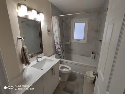 a white bathroom with a sink and a toilet at UofC-SAIT-Banff Trail-Suite A&B in Calgary