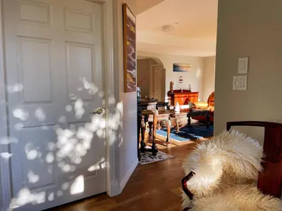 a white dog laying on the floor in front of a door at Spacious and quiet garden view room in Kelowna