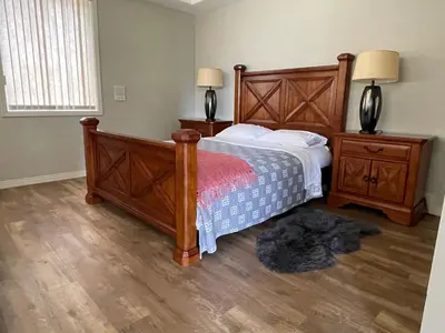 a bedroom with a bed and two night stands and two lamps at Spacious and quiet garden view room in Kelowna