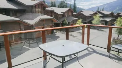 a balcony with a table and chairs on top of a building at Woodhaven #19 by Bear Country in Sun Peaks