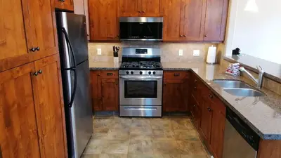 a kitchen with stainless steel appliances and wooden cabinets at Woodhaven #19 by Bear Country in Sun Peaks