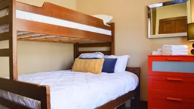 a bedroom with a bunk bed and a red dresser at Stones Throw #24 in Sun Peaks
