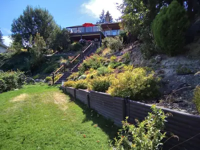 a house on top of a hill with a fence at Hannie's Gasthuis in Blind Bay