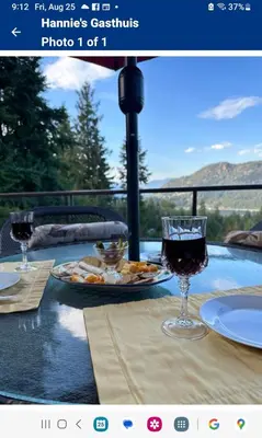 a table with a plate of food and wine glasses at Hannie's Gasthuis in Blind Bay