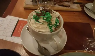 a white cup and saucer with a cake on a table at Ski-in Ski-out at upper village next to Fairmount Hotel In Whistler in Whistler