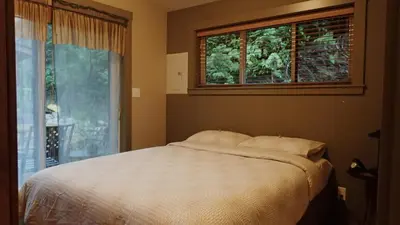 a bedroom with a bed and a window at Wild Coast Chalets in Port Renfrew