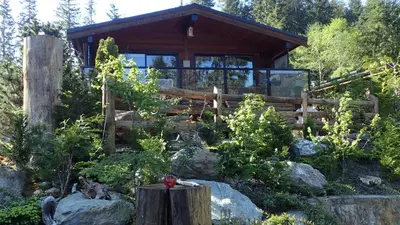 a house in the woods with a fence at Wild Coast Chalets in Port Renfrew