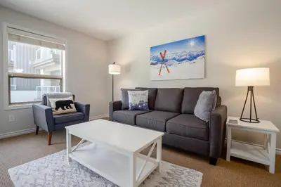 a living room with a couch and a table at 1BR in The Aspens, King Bed, True Ski In, Ski Out, Hot Tubs and Pool, Ski Valet, Private Balcony in Whistler