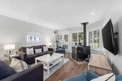 a living room with a couch and a tv at 2BR in Snowberry, Wood Burning Fireplace, Modern Finishes, Parking, Ski Hill Shuttle in Whistler