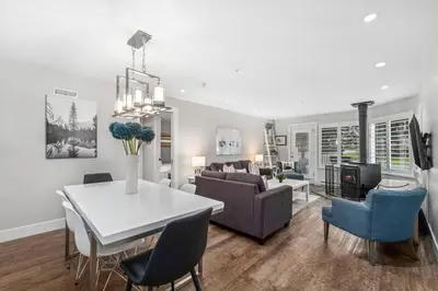 a dining room and living room with a table and chairs at 2BR in Snowberry, Wood Burning Fireplace, Modern Finishes, Parking, Ski Hill Shuttle in Whistler