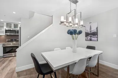 a white dining room with a white table and chairs at 2BR in Snowberry, Wood Burning Fireplace, Modern Finishes, Parking, Ski Hill Shuttle in Whistler