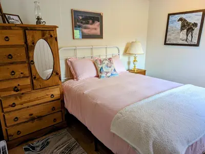 a bedroom with a bed with a dresser and a mirror at The Cottage on the Farm in Ladysmith