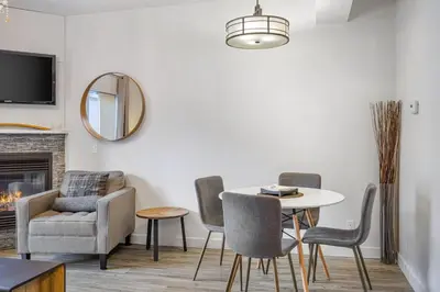 a living room with a table and chairs and a mirror at Newly renovated Blue Sky - Family Fun - 2 Bed -2 Bath in Canmore