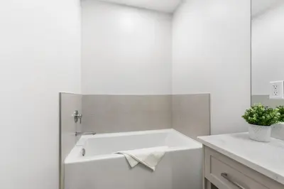a white bath tub in a bathroom with a sink at Beach Suites in Parksville
