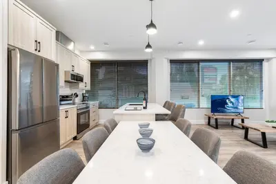 a kitchen with a table and chairs in a room at Beach Suites in Parksville