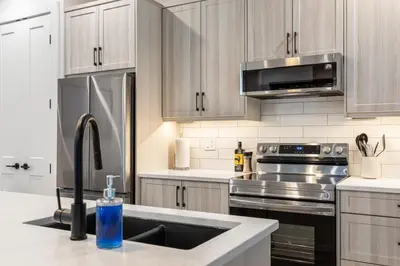a kitchen with stainless steel appliances and a sink at Beach Suites in Parksville