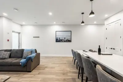 a living room with a long table and chairs at Beach Suites in Parksville