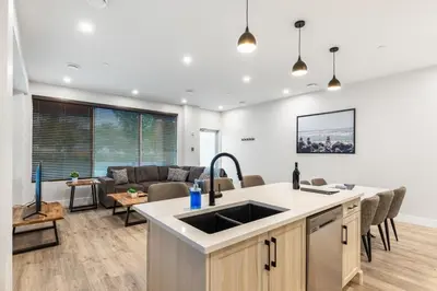an open kitchen and living room with a couch at Beach Suites in Parksville