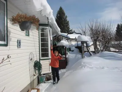a person standing outside of a house in the snow at The Grateful Bed B'n'B in Prince George