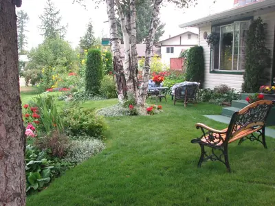 a park bench sitting in the yard of a house at The Grateful Bed B'n'B in Prince George