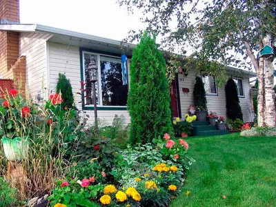 a house with a garden of flowers in the yard at The Grateful Bed B'n'B in Prince George