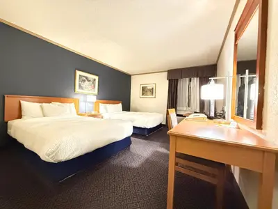 a hotel room with two beds and a desk at Days Inn by Wyndham Drayton Valley in Drayton Valley