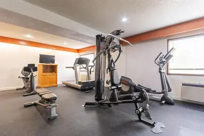 a gym with treadmills and exercise bikes in a room at Days Inn by Wyndham Drayton Valley in Drayton Valley