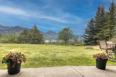 a view of a field with a bench and flowers at Pine Ridge, Log Home with Lake View and Backyard in Invermere