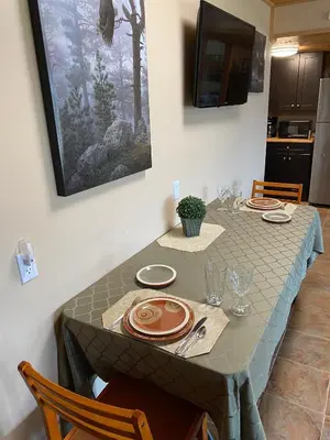 a dining room table with plates and glasses on it at Pine Ridge, Log Home with Lake View and Backyard in Invermere