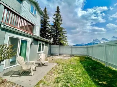 a backyard with two chairs and a fence at Nakiska, 2 Bed 1 Bath with Mtn Views in Canmore