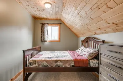 a bedroom with a bed with a wooden ceiling at Whiskey Jack, 4 Bedroom Cabin with Outdoor Firepit in Sunshine Valley